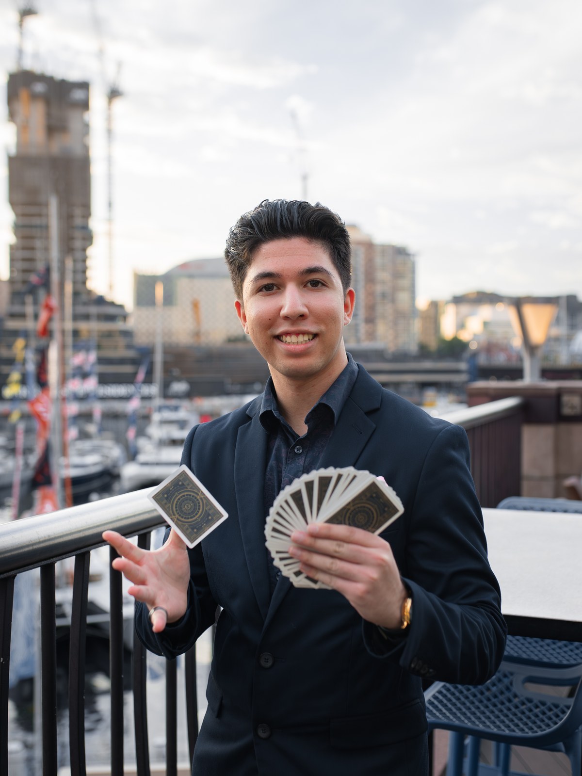 TDog with a fan of playing cards on a Sydney harbourside terrace
